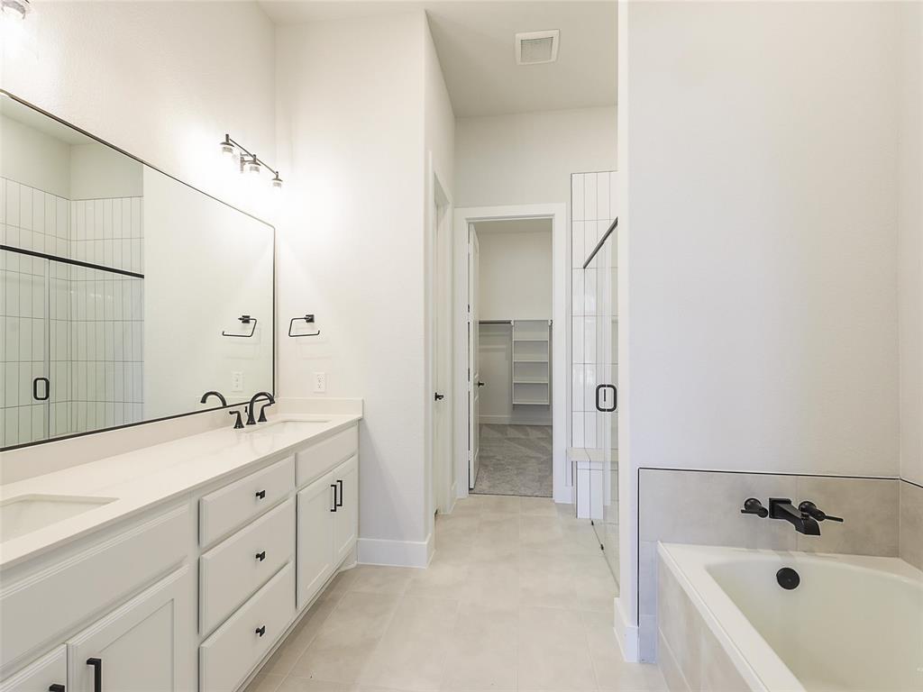 4299 Reeder Rdg Way Frisco, TX 75033 - Photo 17 of 30 a spacious bathroom with a double vanity sink a mirror and a bathtub