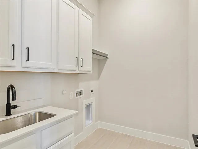 a kitchen with white cabinets and sink