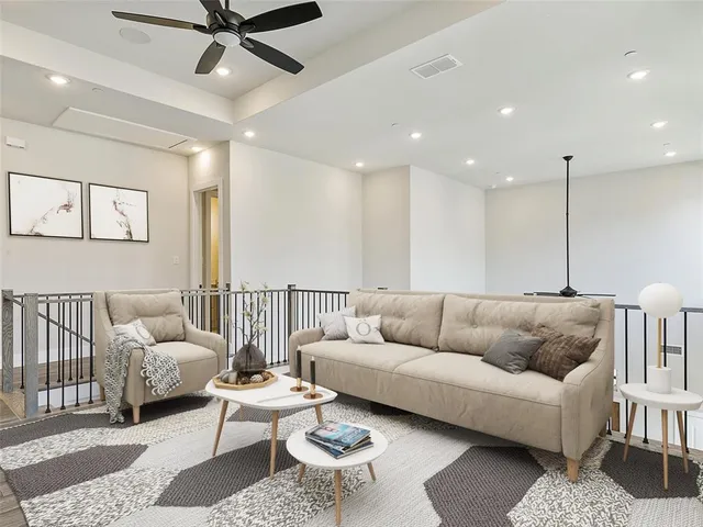 a living room with furniture and a ceiling fan