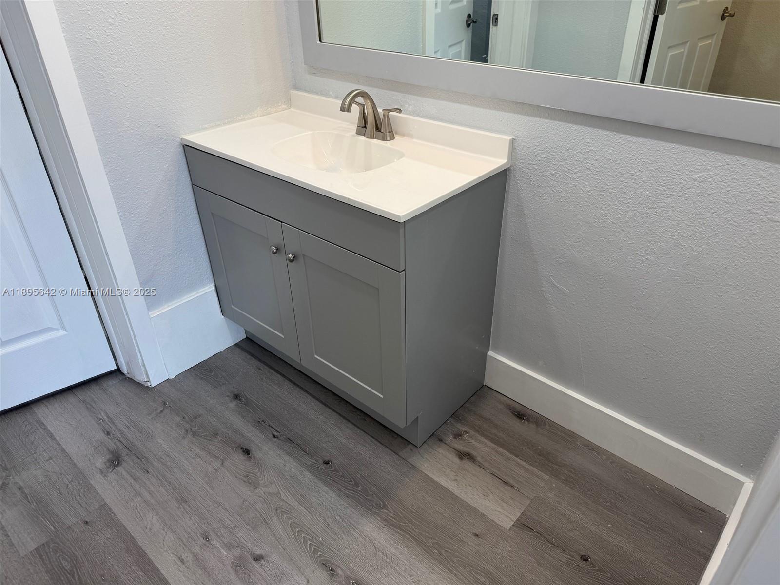 494 Northwest 165th Street, Unit C207 Miami, FL 33169 - Photo 12 of 14 a bathroom with a sink and mirror