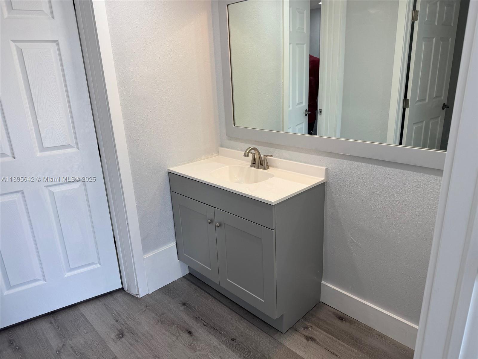 494 Northwest 165th Street, Unit C207 Miami, FL 33169 - Photo 13 of 14 a bathroom with a sink and a mirror