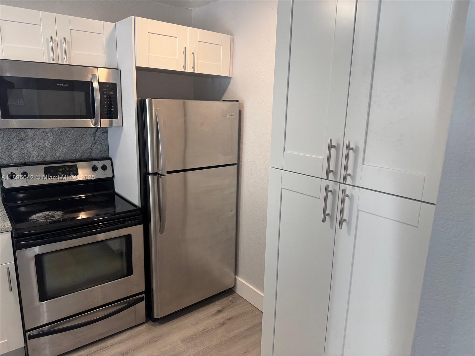 494 Northwest 165th Street, Unit C207 Miami, FL 33169 - Photo 3 of 14 a white refrigerator freezer and a stove sitting inside of a kitchen