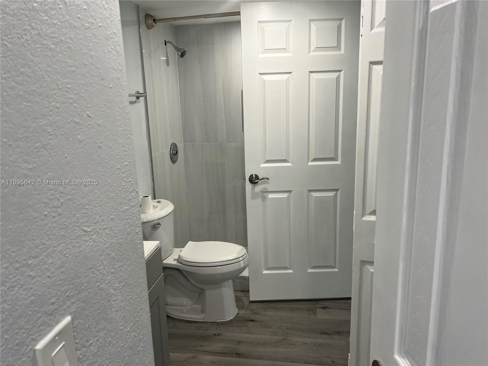 494 Northwest 165th Street, Unit C207 Miami, FL 33169 - Photo 5 of 14 a white toilet sitting next to a bathroom sink