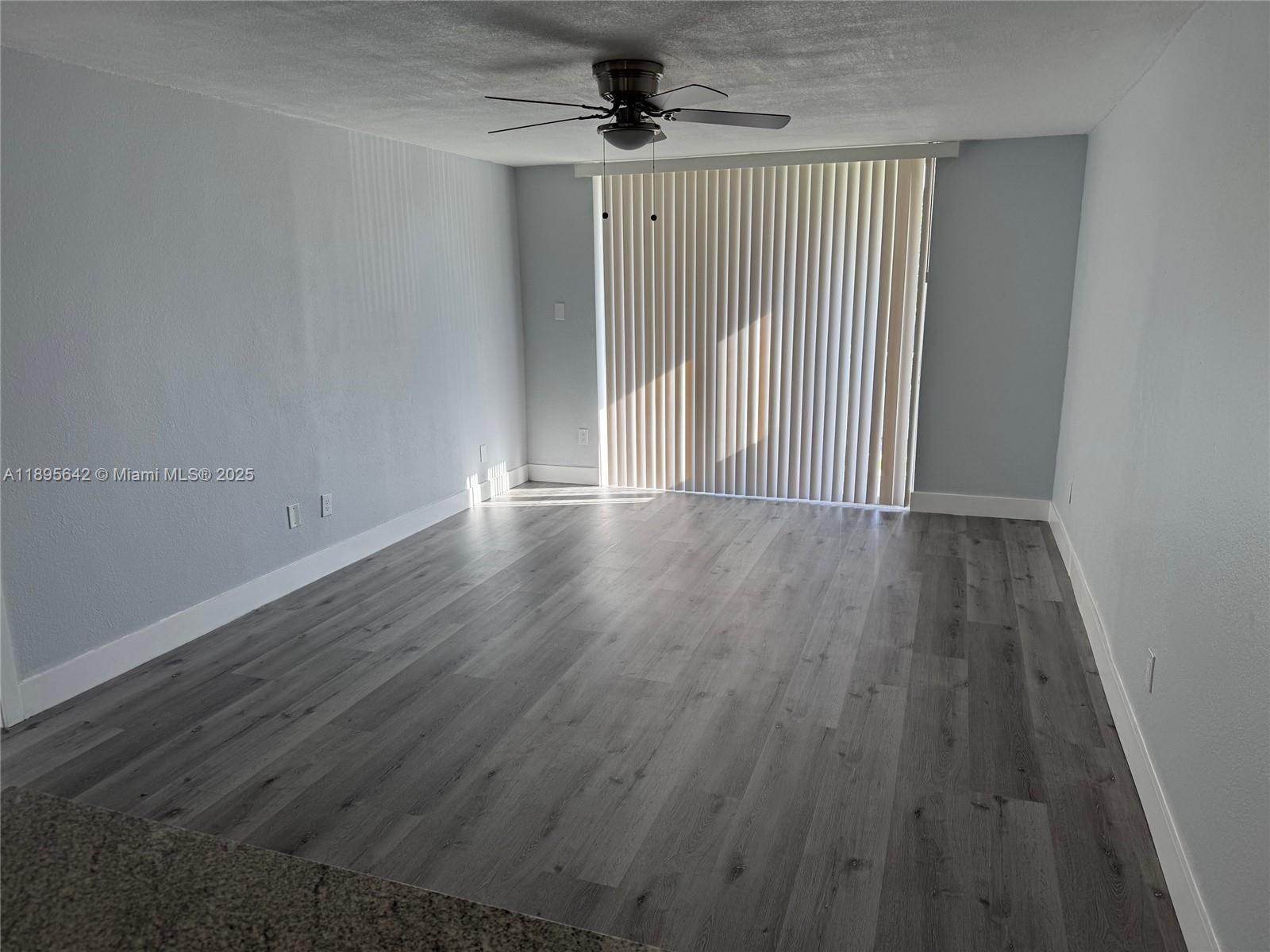 494 Northwest 165th Street, Unit C207 Miami, FL 33169 - Photo 8 of 14 wooden floor in an empty room with a window