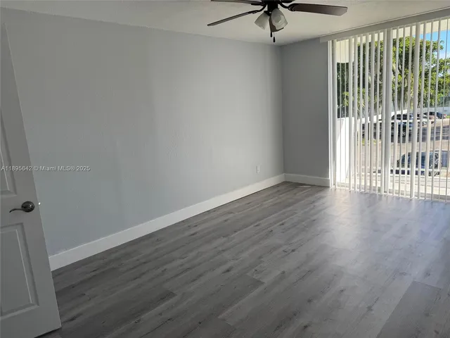 a view of a livingroom with wooden floor and a ceiling fan