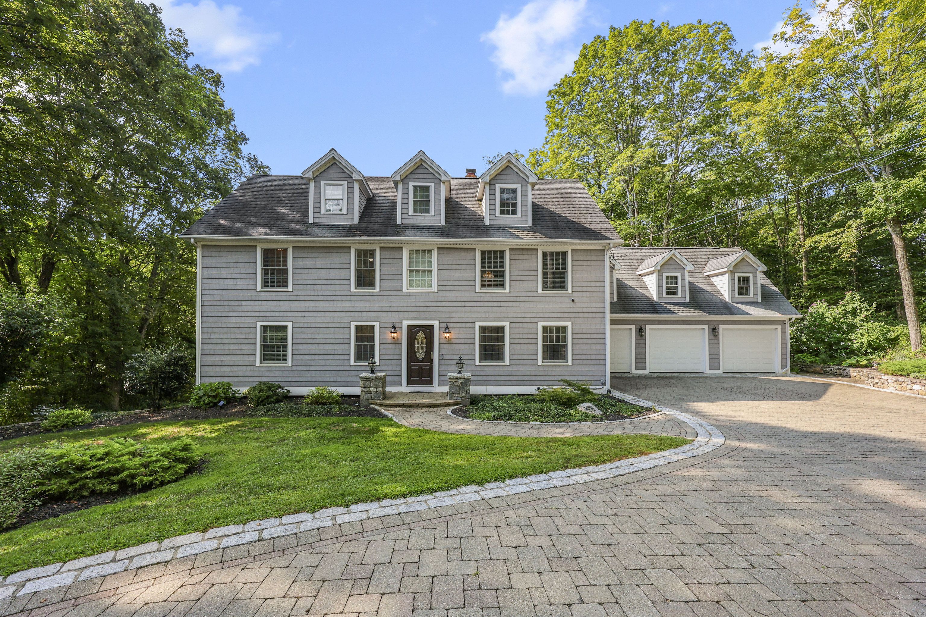 a front view of a house with a yard and trees
