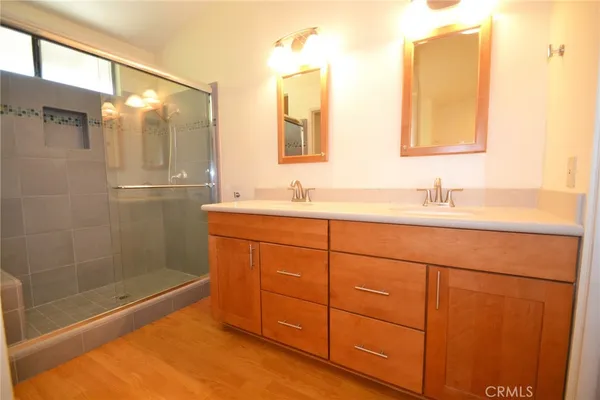 a bathroom with a double vanity sink mirror and shower