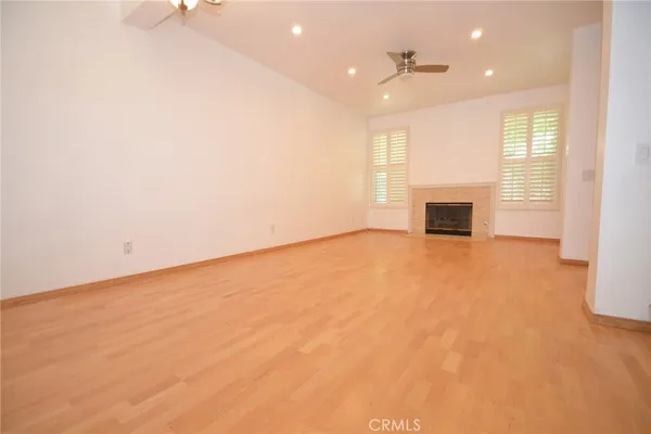 an empty room with fireplace and windows