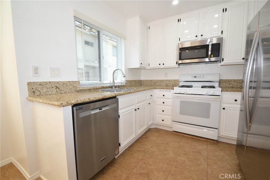 2615 Plaza Del Amo, Unit 636 Torrance, CA 90503 - Photo 6 of 22 a kitchen with white cabinets stainless steel appliances and sink