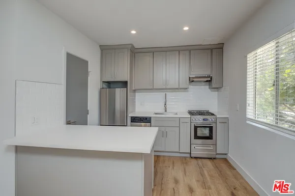 a kitchen with stainless steel appliances granite countertop a stove a sink and a refrigerator