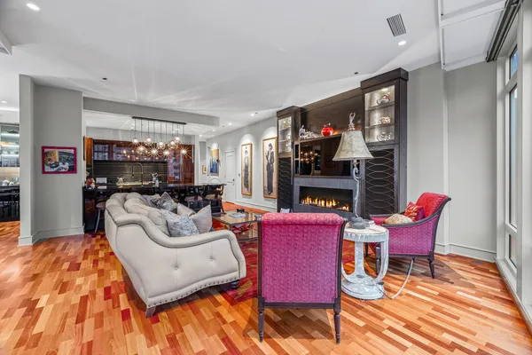 a dining room with stainless steel appliances granite countertop a table chairs and a living room view