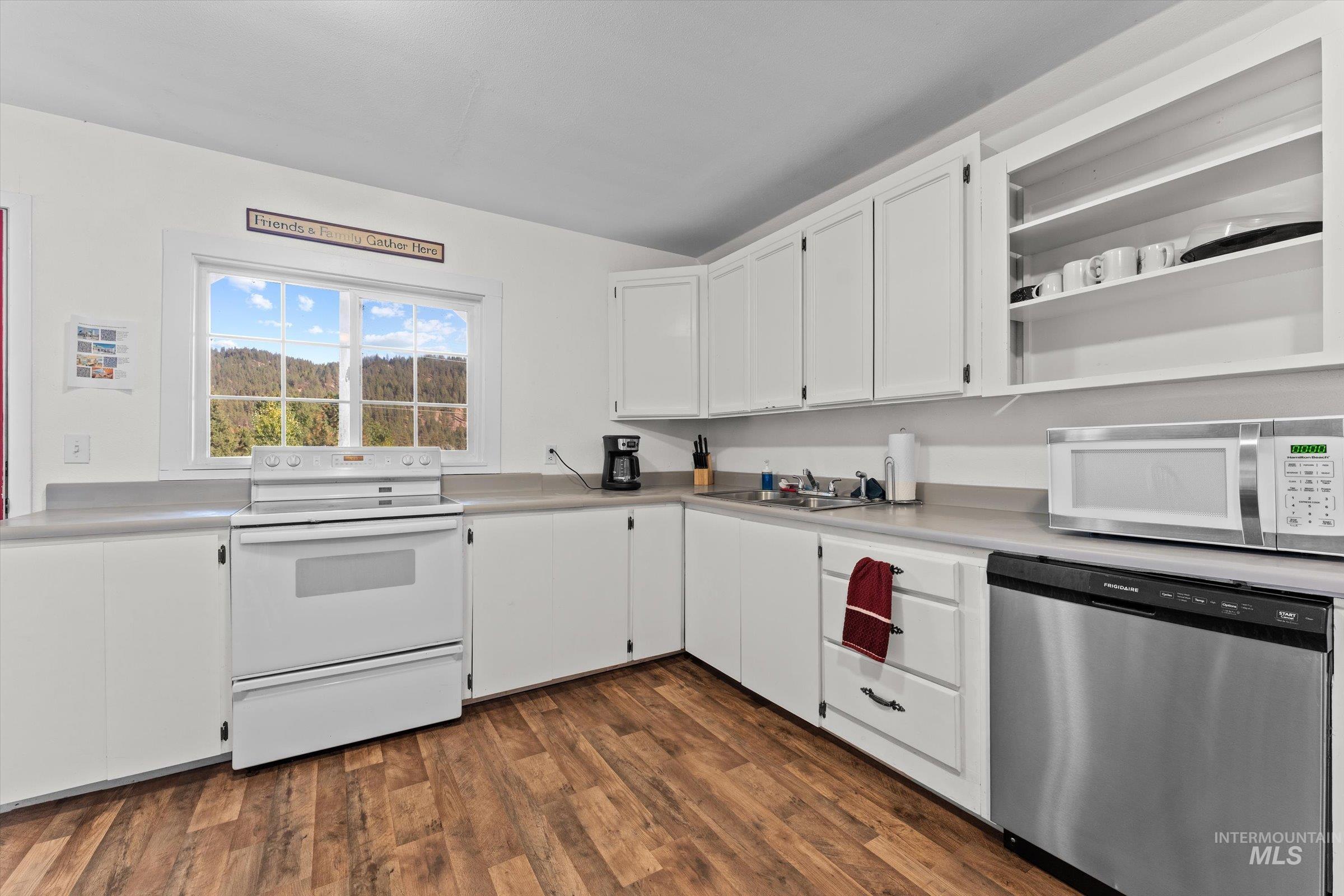 315 South Middlefork Road Garden Valley, ID 83622 - Photo 24 of 49 Kitchen featuring stainless steel dishwasher, white cabinetry, white electric stove, light countertops, and dark wood-type flooring