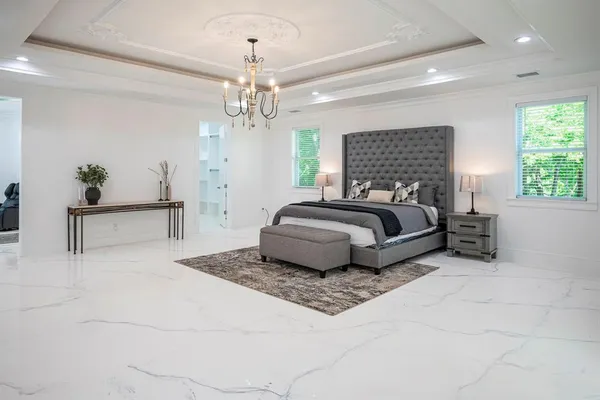 a spacious bedroom with a bed and a chandelier