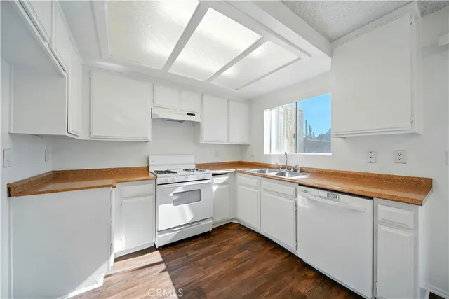 a kitchen with stainless steel appliances granite countertop a sink and cabinets with wooden floor