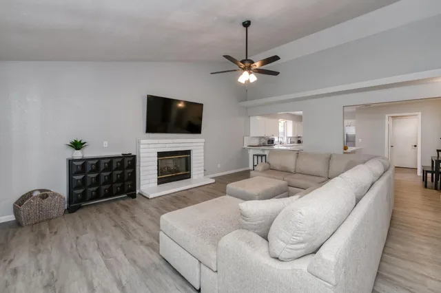 a living room with furniture a flat screen tv and a fireplace