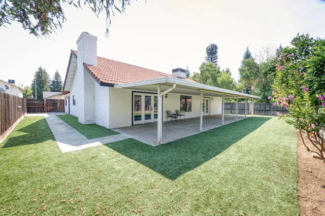 a view of a house with a yard and sitting area