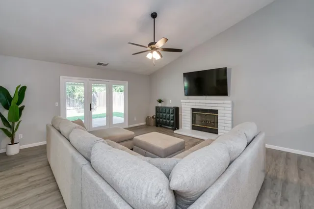 a living room with furniture a fireplace and a flat screen tv