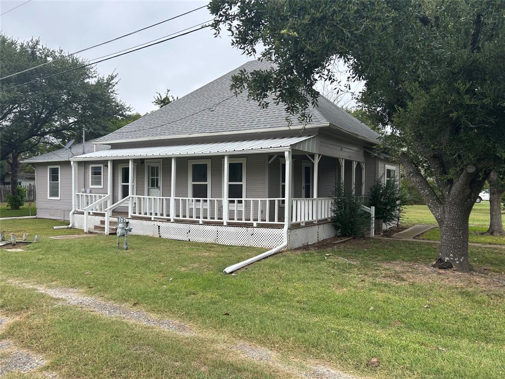 a view of a house with a yard and large tree