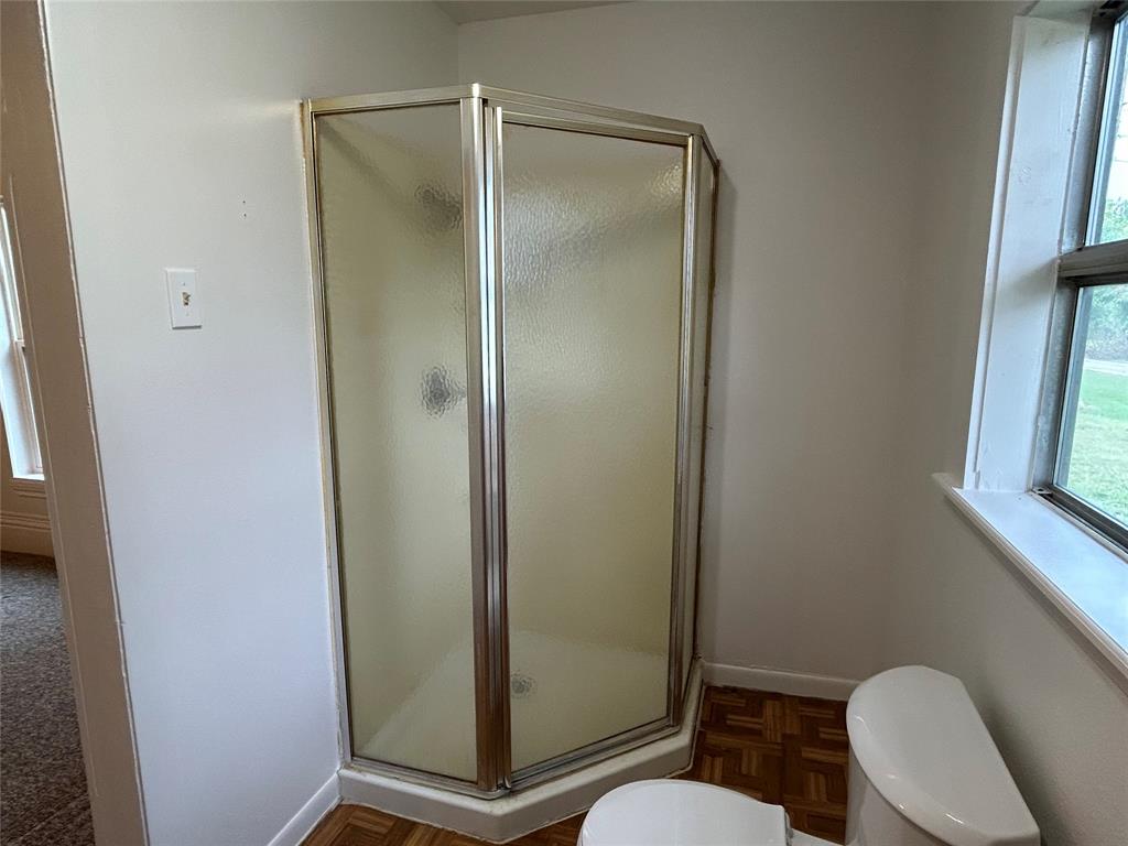 302 North Commerce Savoy, TX 75479 - Photo 11 of 32 a bathroom with a shower a toilet and a sink