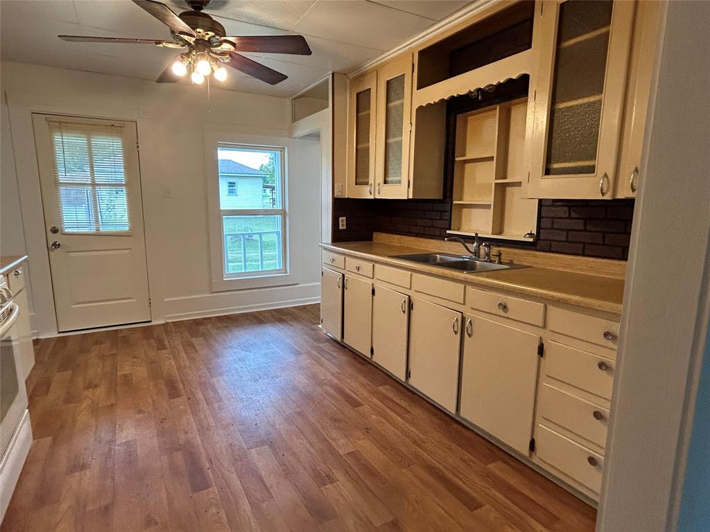 302 North Commerce Savoy, TX 75479 - Photo 18 of 32 a view of a kitchen with cabinets and wooden floor