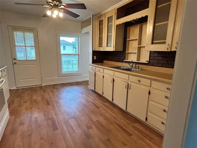 a view of a kitchen with cabinets and wooden floor