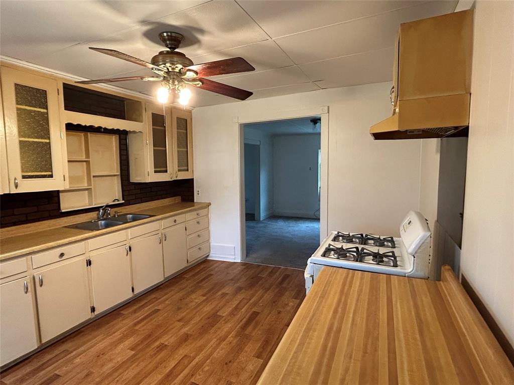 302 North Commerce Savoy, TX 75479 - Photo 21 of 32 a kitchen with a sink and a stove top oven