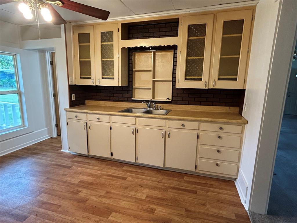 302 North Commerce Savoy, TX 75479 - Photo 22 of 32 a view of a kitchen with a sink a microwave and cabinets