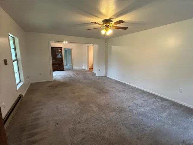 a view of an empty room with a chandelier fan