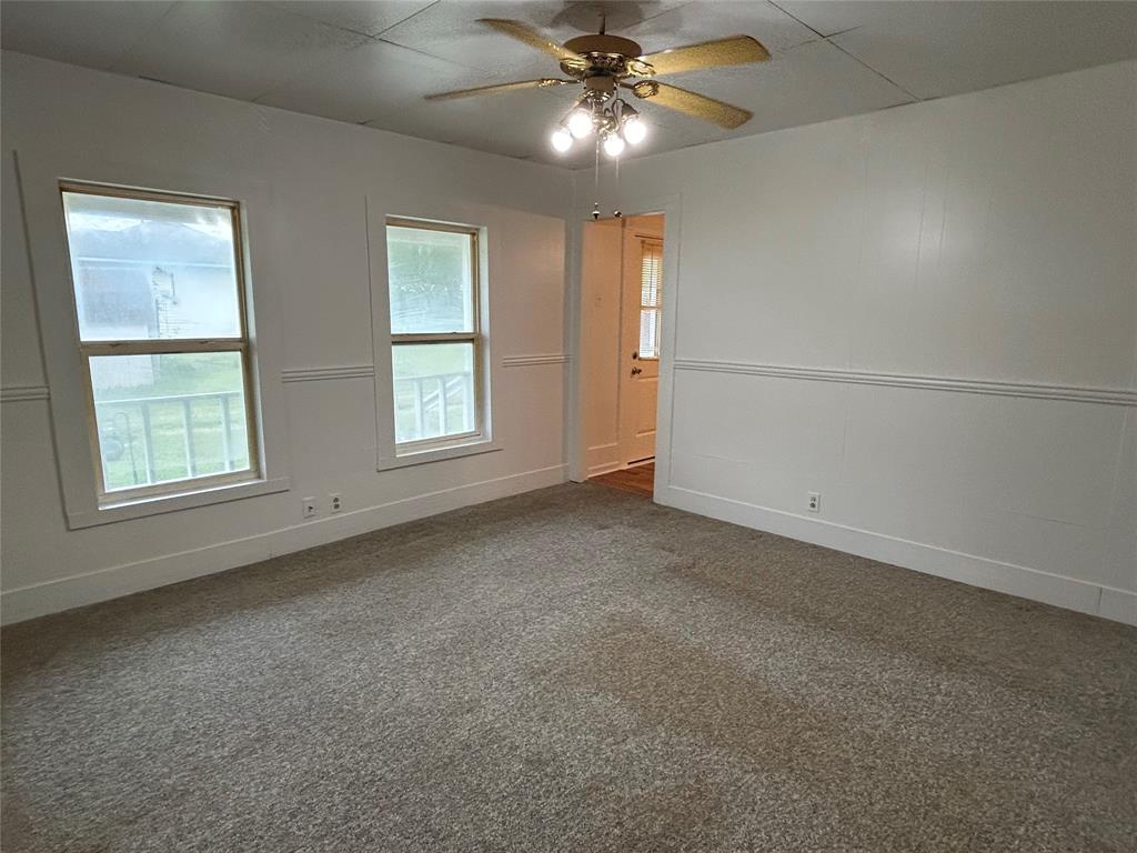 302 North Commerce Savoy, TX 75479 - Photo 4 of 32 an empty room with windows and fan