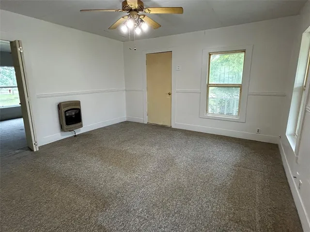an empty room with windows and fireplace