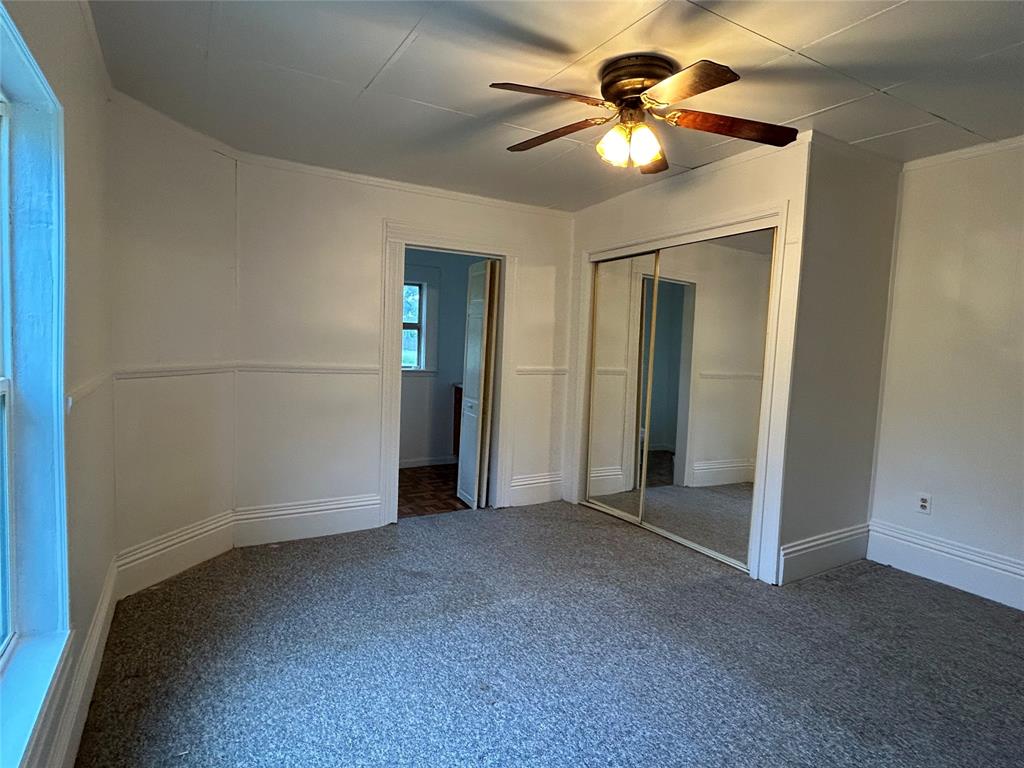 302 North Commerce Savoy, TX 75479 - Photo 9 of 32 an empty room with closet and a chandelier fan