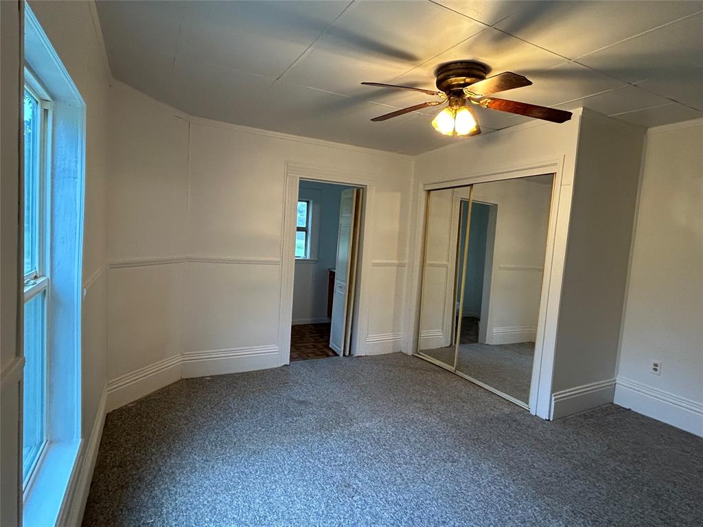 302 North Commerce Savoy, TX 75479 - Photo 10 of 32 an empty room with closet and a chandelier fan
