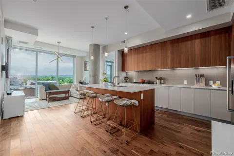 a kitchen with stainless steel appliances granite countertop a stove a sink dishwasher and a refrigerator with wooden floor