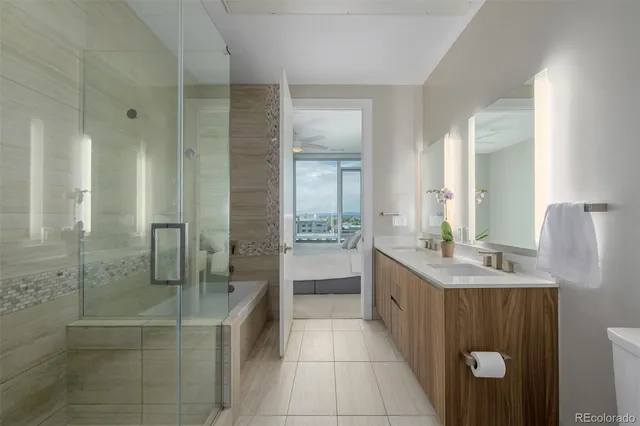 a bathroom with a granite countertop sink a mirror and a shower