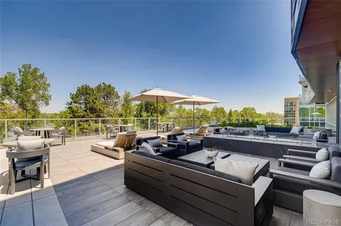 a roof deck with couches and umbrella