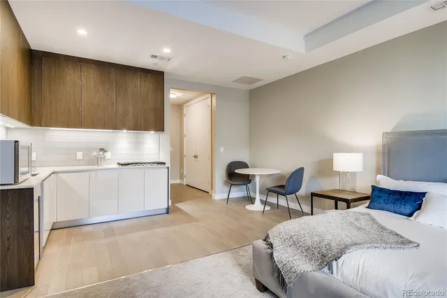 a spacious bedroom with a bed a couch and a dresser in it