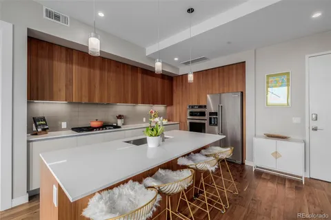 a kitchen with stainless steel appliances granite countertop a refrigerator a stove top oven a sink and cabinets