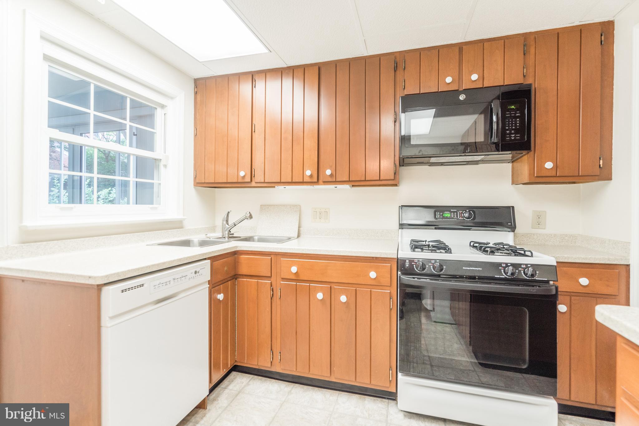 6104 28th Street North Arlington, VA 22207 - Photo 12 of 30 a kitchen with granite countertop a stove top oven microwave and cabinets