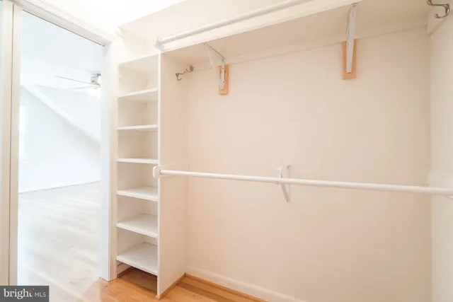 a view of walk in closet with empty racks