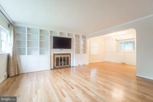 a view of a livingroom with a fireplace wooden floor and window