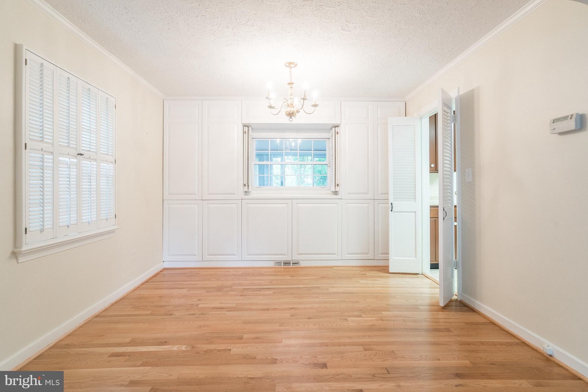 6104 28th Street North Arlington, VA 22207 - Photo 8 of 30 an empty room with wooden floor cabinet and windows