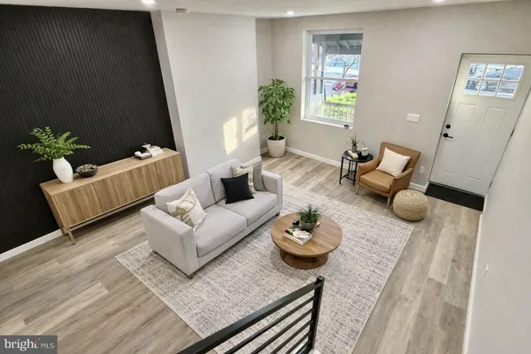 a view of an empty room with wooden floor and stairs