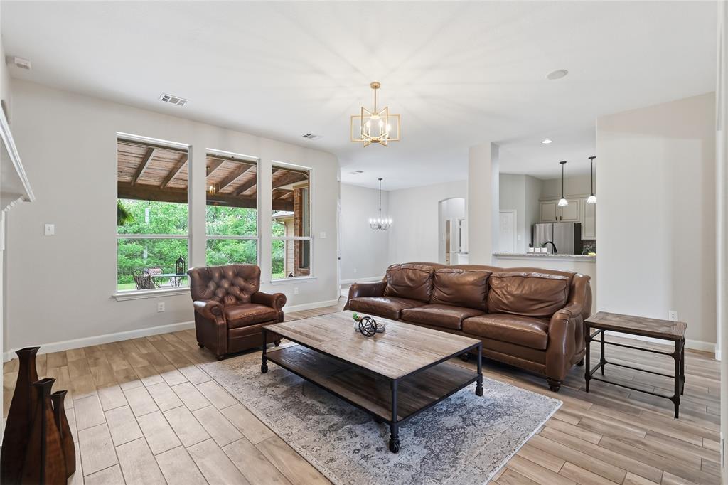 2402 Ravinia Drive Corinth, TX 76208 - Photo 13 of 40 Living area featuring light-toned tile flooring, three large windows, and a modern light fixture