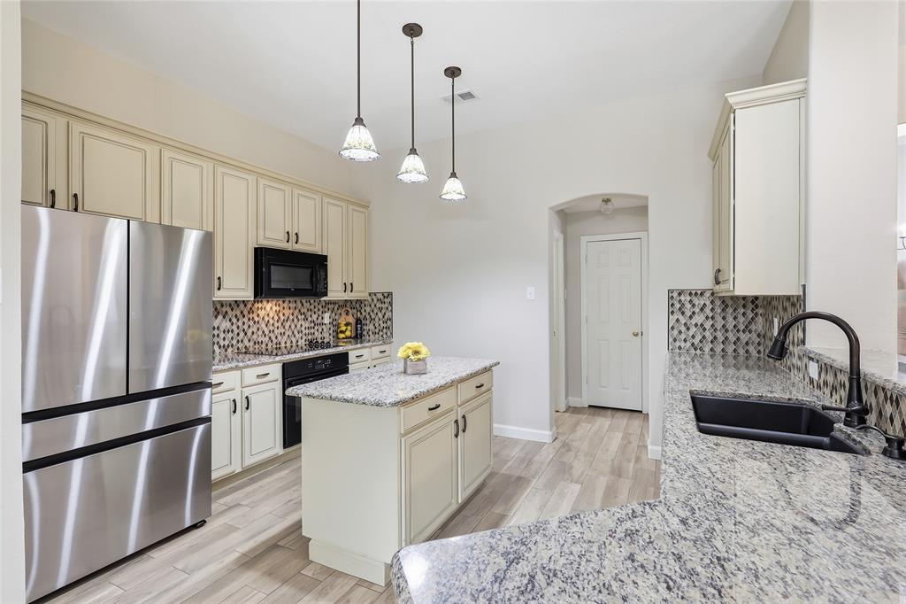 2402 Ravinia Drive Corinth, TX 76208 - Photo 17 of 40 The kitchen features light-colored cabinetry, stainless steel appliances, and granite countertops