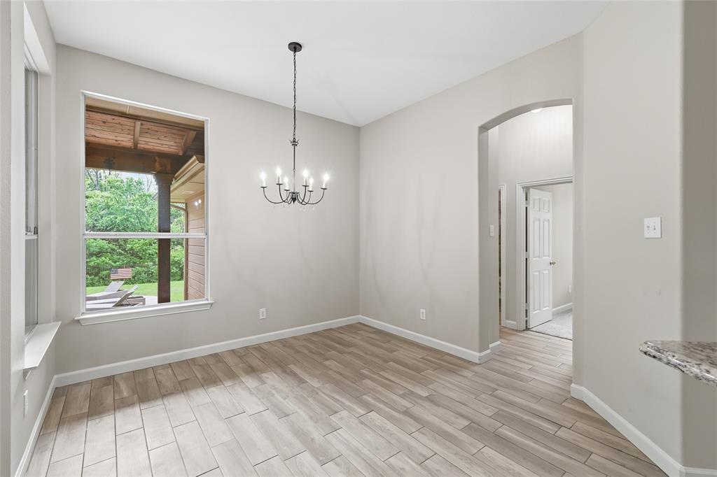 2402 Ravinia Drive Corinth, TX 76208 - Photo 20 of 40 Spacious interior room featuring light-colored flooring, a window providing outdoor views, and a hanging chandelier
