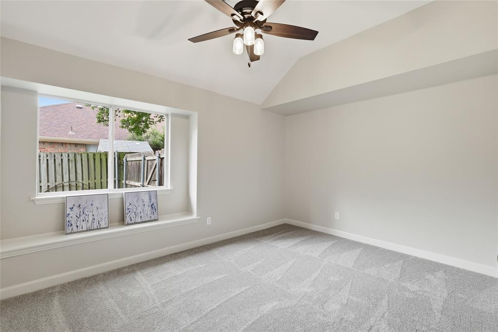 2402 Ravinia Drive Corinth, TX 76208 - Photo 30 of 40 Spacious room featuring vaulted ceilings, a ceiling fan, and newly carpeted flooring