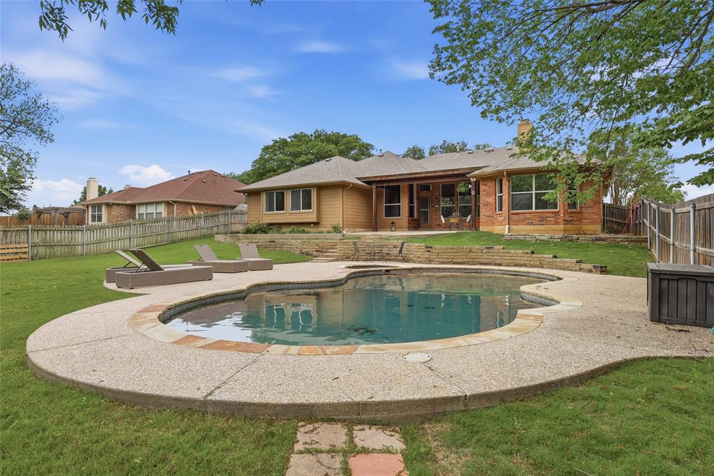 2402 Ravinia Drive Corinth, TX 76208 - Photo 36 of 40 The property features a backyard with a swimming pool, a surrounding patio with multiple seating areas and a large grassy back yard