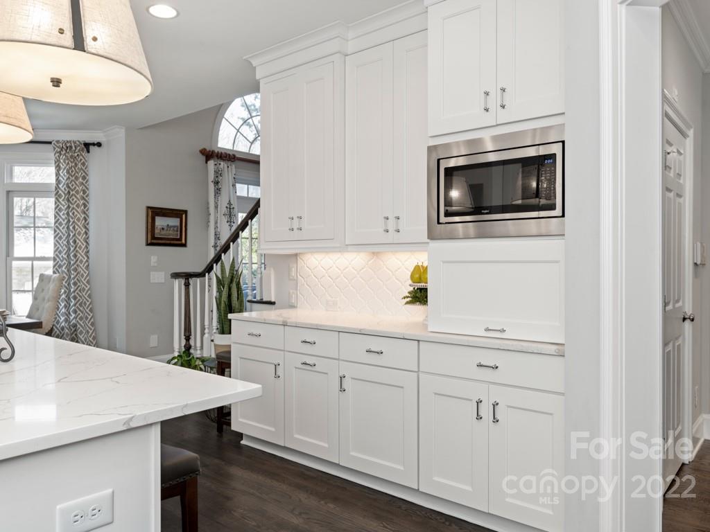 5015 Rea Road Charlotte, NC 28226 - Photo 11 of 48 a kitchen with stainless steel appliances white cabinets and wooden floors