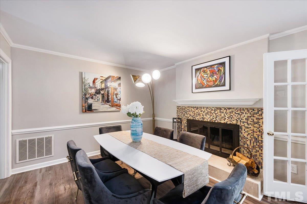 1313 Falls Church Road Raleigh, NC 27609 - Photo 11 of 40 a dining room with furniture a rug and a fireplace