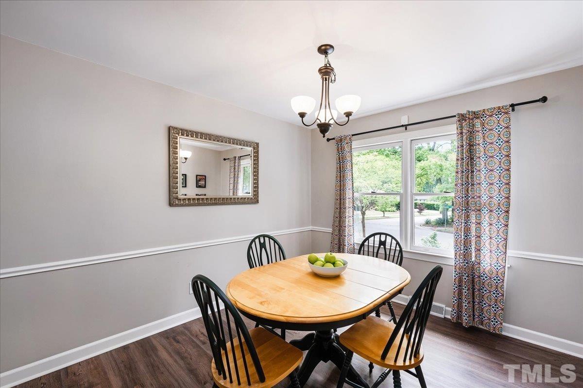 1313 Falls Church Road Raleigh, NC 27609 - Photo 16 of 40 a view of a dining room with furniture window and wooden floor
